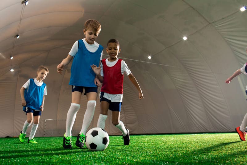 Crianças jogando futebol na festa de aniversário infantil