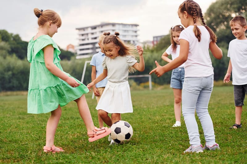 Crianças jogando futebol society na quadra