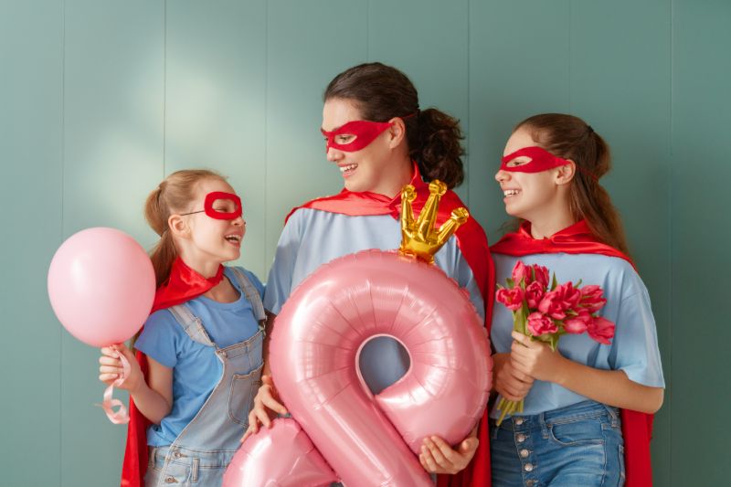 Mãe e suas duas filhas fantasiadas de super heróis