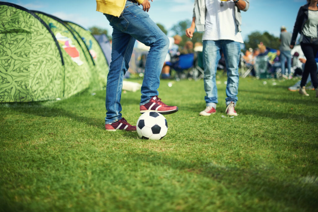 Pessoas interagindo durante aniversário em quadra de futebol