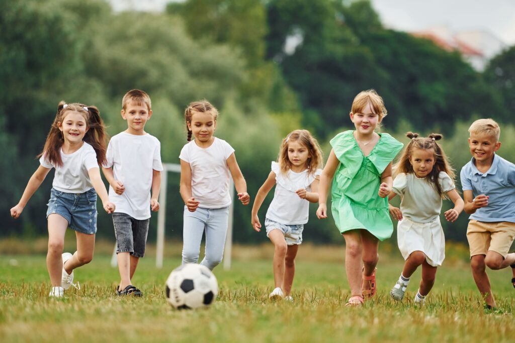 Crianças jogando futebol em campo